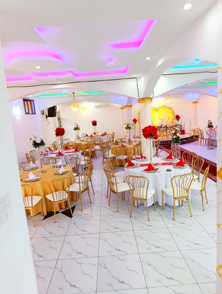 Salle Haut de Gamme dressée en rouge et blanc avec plafond LED et chaises dorées