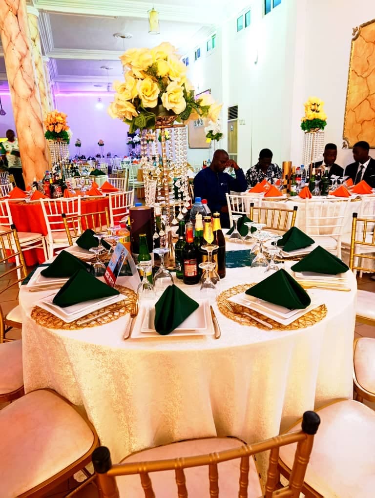 Tables rondes dressées en vert et or avec chaises Chiavari dorées dans la Grande Salle Prestige